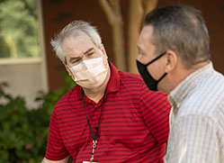 Photo of two men wearing masks. 